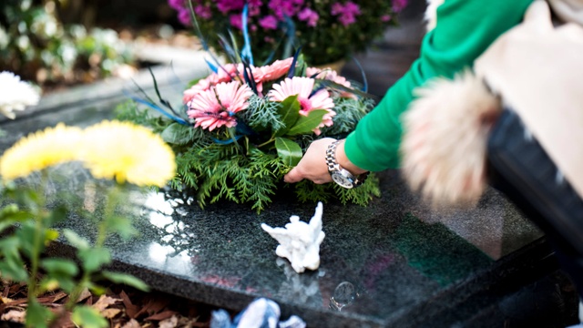Someone laying flowers at a funeral