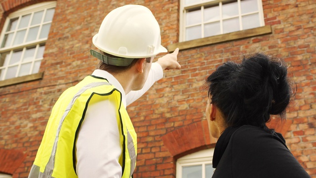 man surveying house