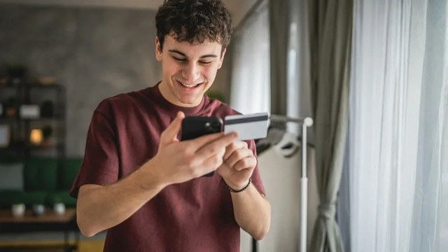 Young man with a credit card in his hand and a mobile phone