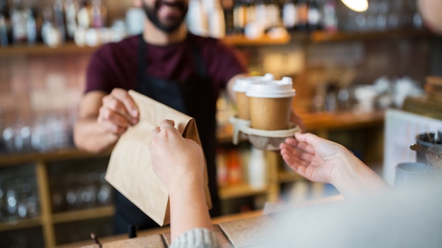 person buying takeaway coffee from server