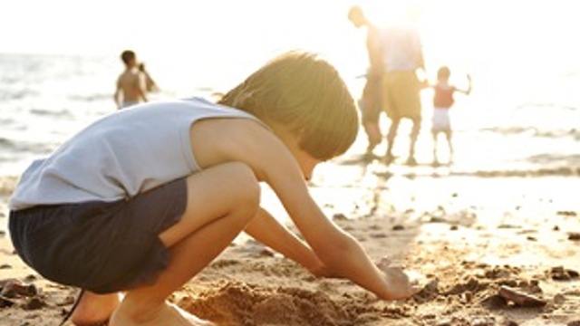 child playing in the sand on the beach