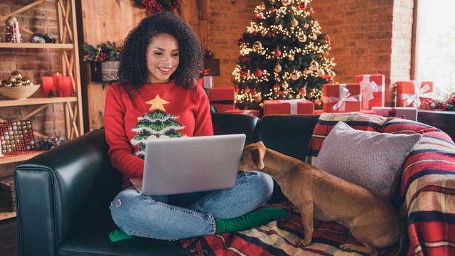 Woman online shopping with a Christmas jumper on