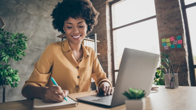 woman on laptop with notepad