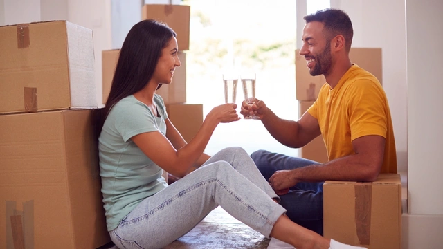 first time buyers toasting to their new home surrounded by boxes