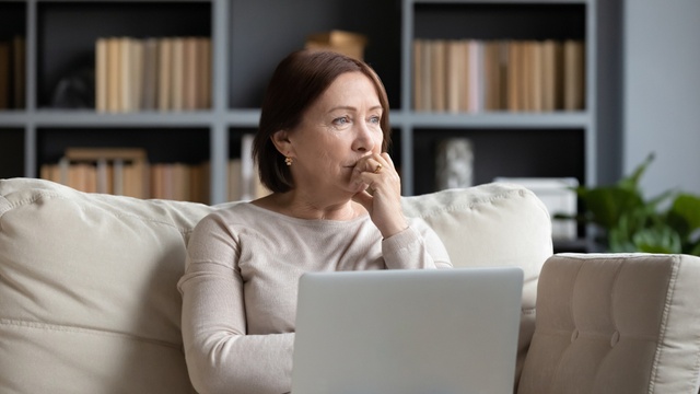 Woman using a laptop with a concerned expression