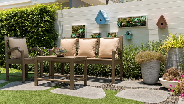 cosy corner of a small garden with painted wall and outdoor furniture