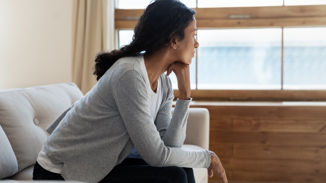 Woman sat by window thinking