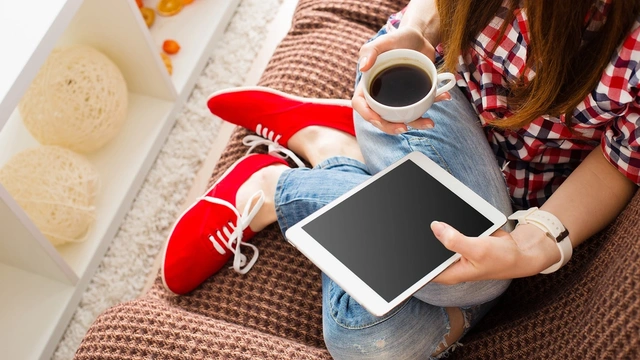 woman on ipad with cup of tea
