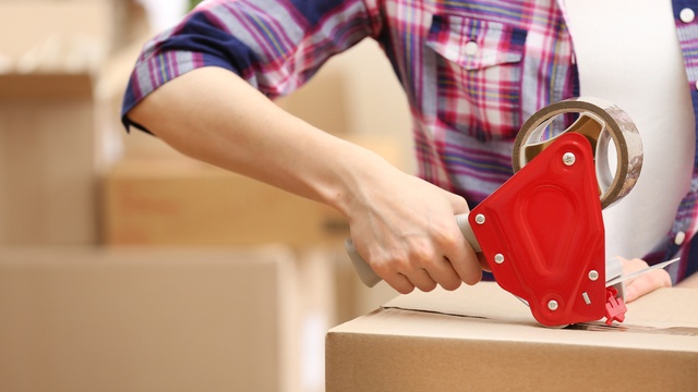 Person packaging moving boxes