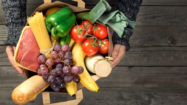 Bag of groceries including meat, pasta bread and vegetables