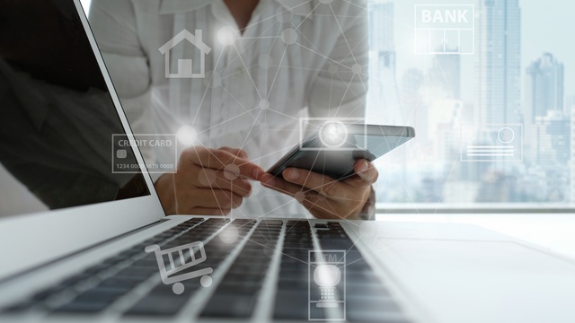 Person on phone by laptop