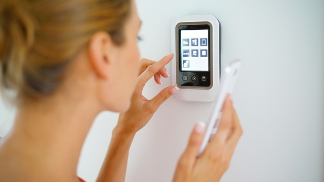 woman using smartphone to control electrical appliances