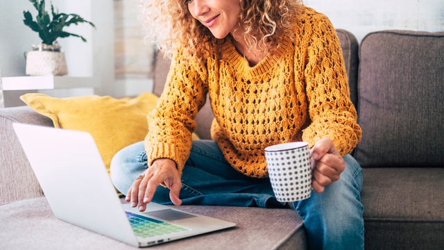 Woman on laptop drinking coffee