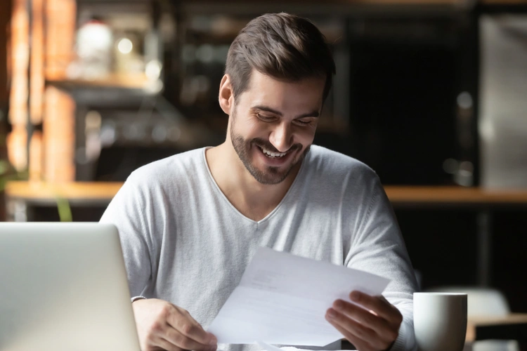 man smiling looking at letter