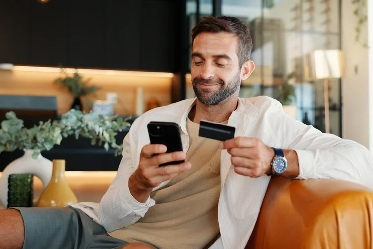 Man holding a credit card and his mobile phone