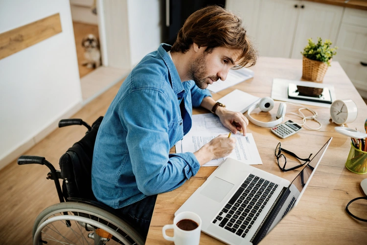 man in wheelchair filing in paperwork