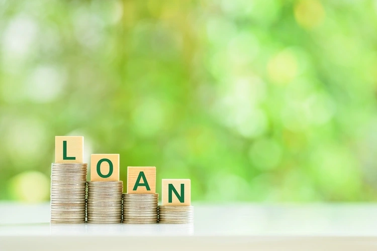 The word loan written in cubes on stacks of coins