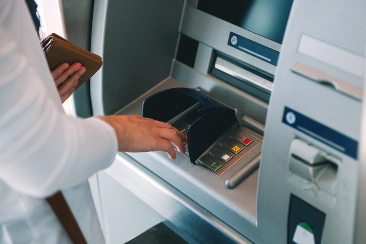 A person withdrawing cash from an ATM