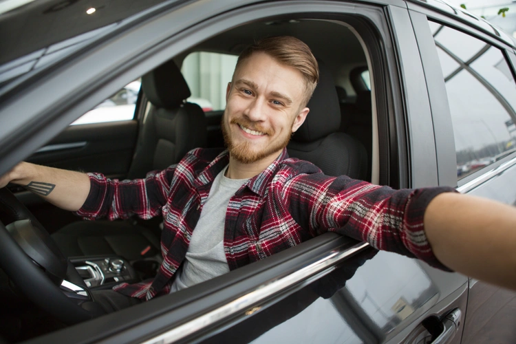man in driving seat smiling