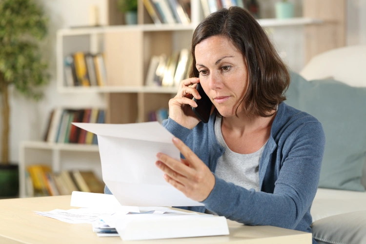 woman on phone checking letter