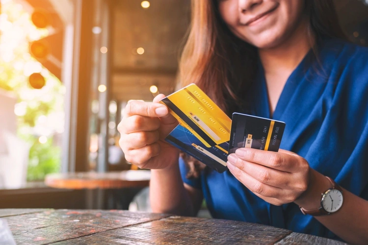 Woman smiling with a number of credit cards in her hands.