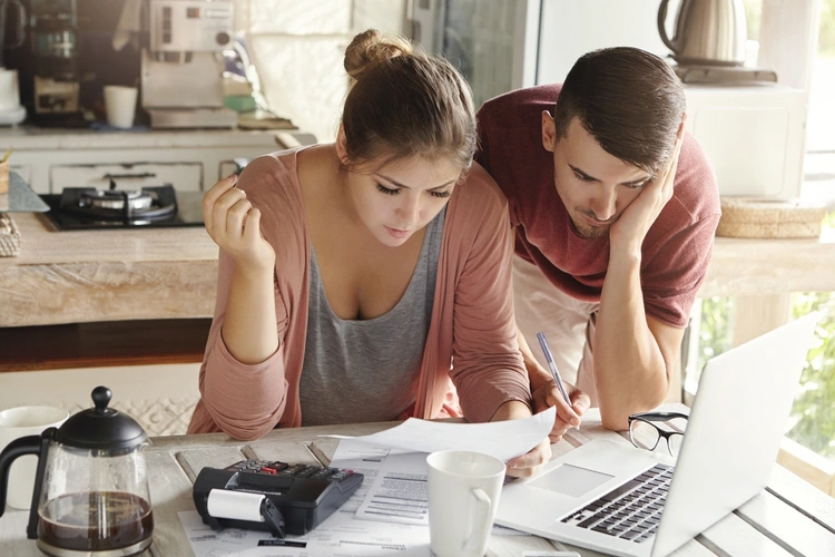 Young married couple with many debts doing paperwork together
