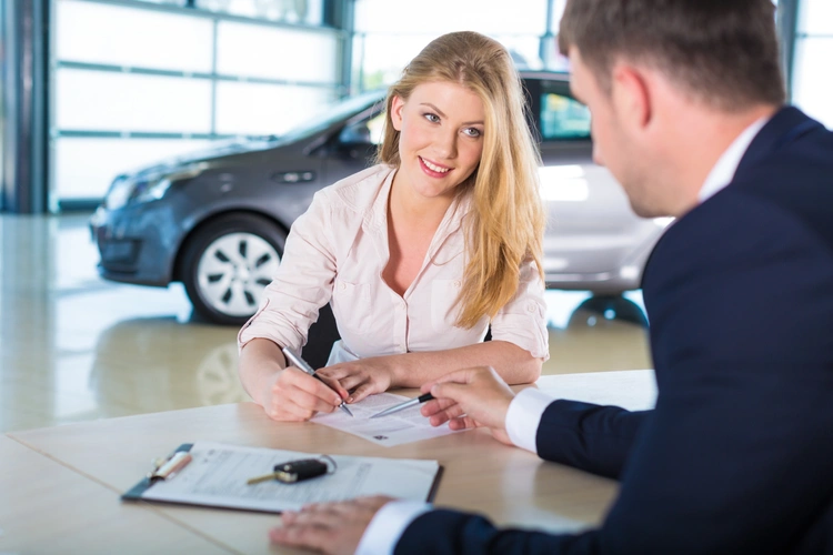 Woman signing car finance 