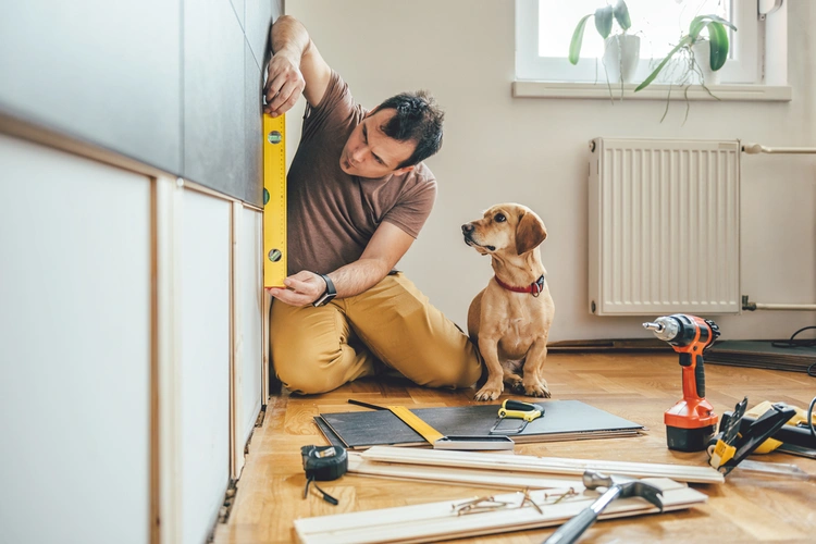 man renovating home with dog watching