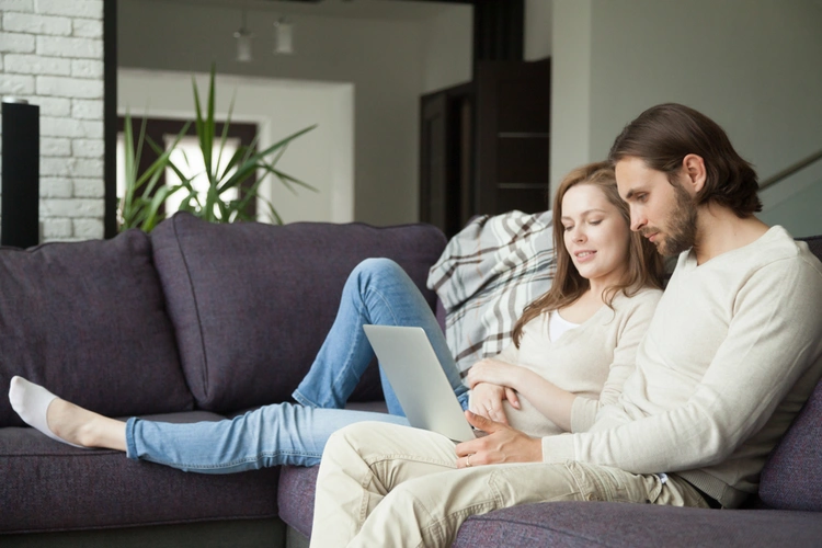Couple on the couch looking at a laptop