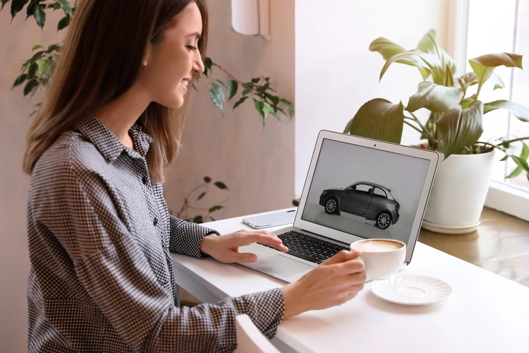 Woman on laptop looking at a car