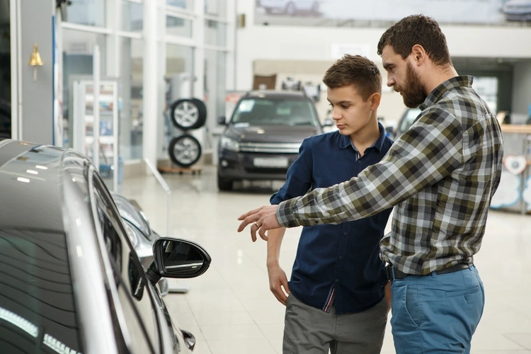 boy buying car with dad