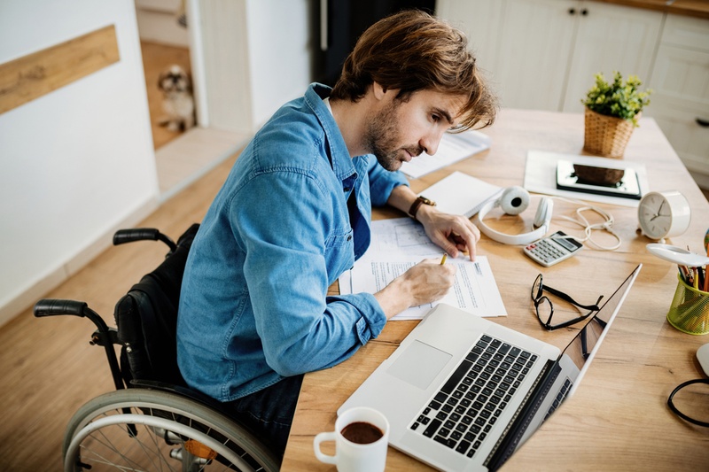 man in wheelchair filing in paperwork