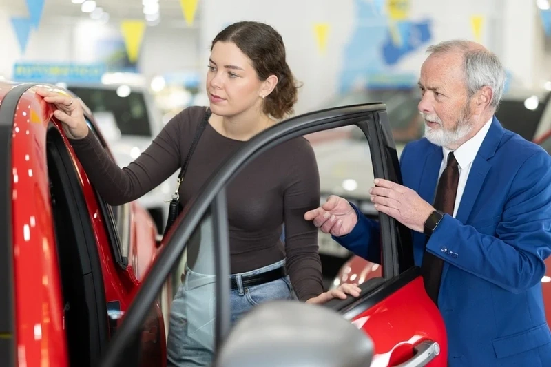 Woman viewing a new car in showroom
