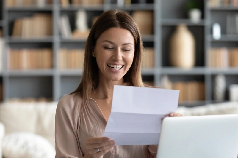 Woman reading loan documents and smiling