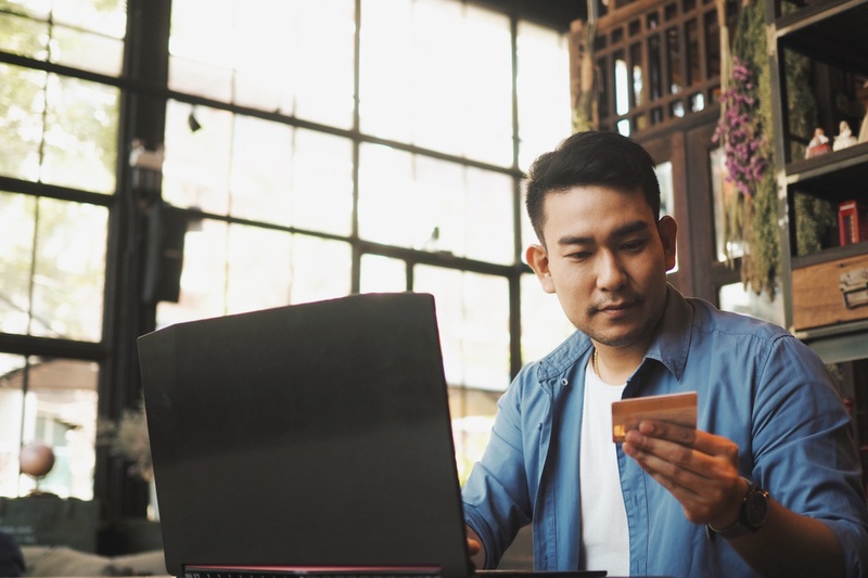 Man on his laptop, looking at credit card