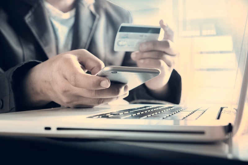 Man making a purchase on his laptop using a credit card.