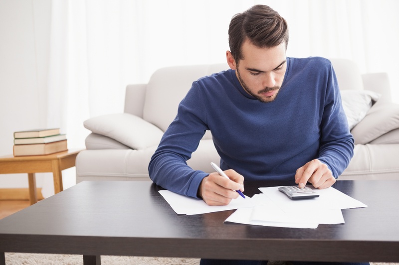 man working out bills with calculator