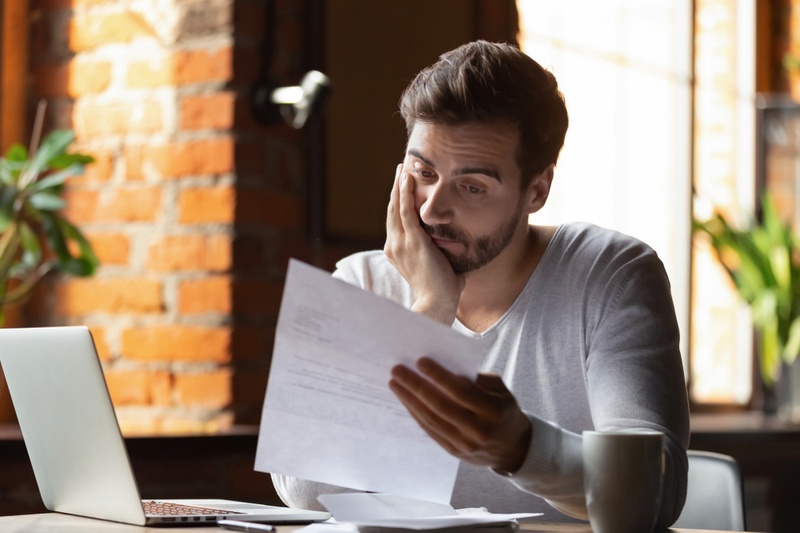 A young man looking at a credit card statement 