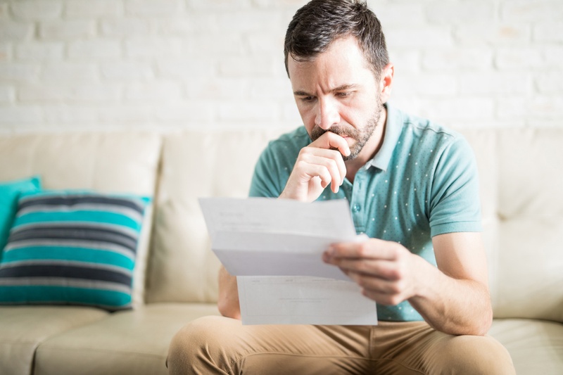 stressed man looking at bank statements