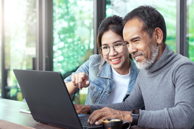 Father and daughter at a laptop looking at loans