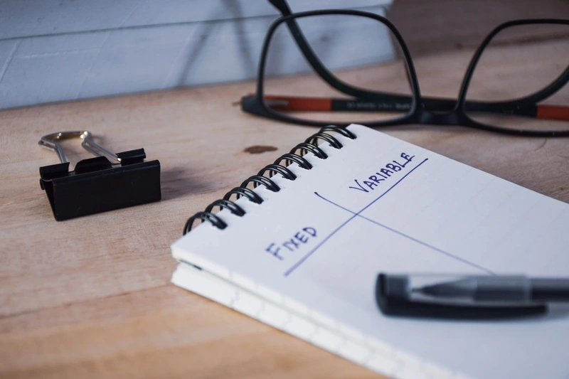 A notepad with the words fixed and variable written in two separate columns