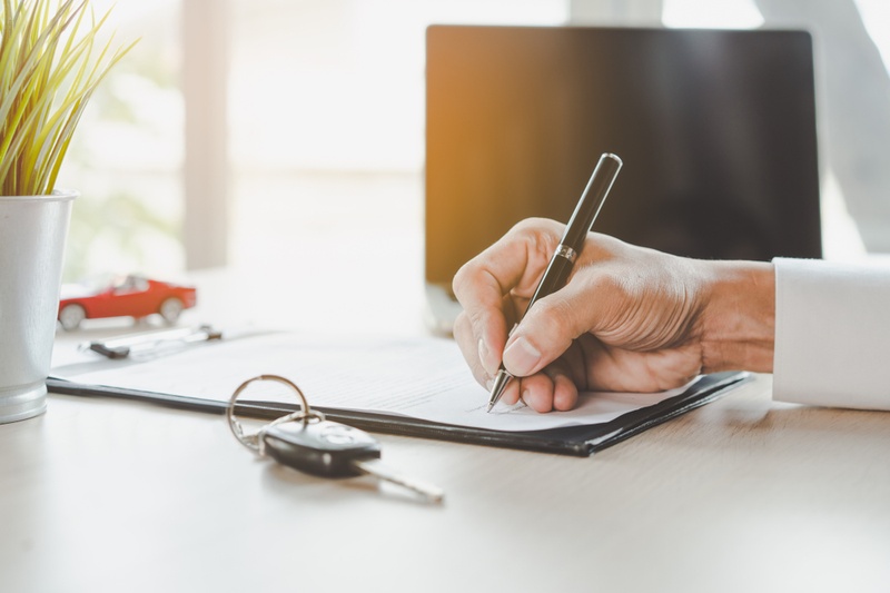 man signing car contract