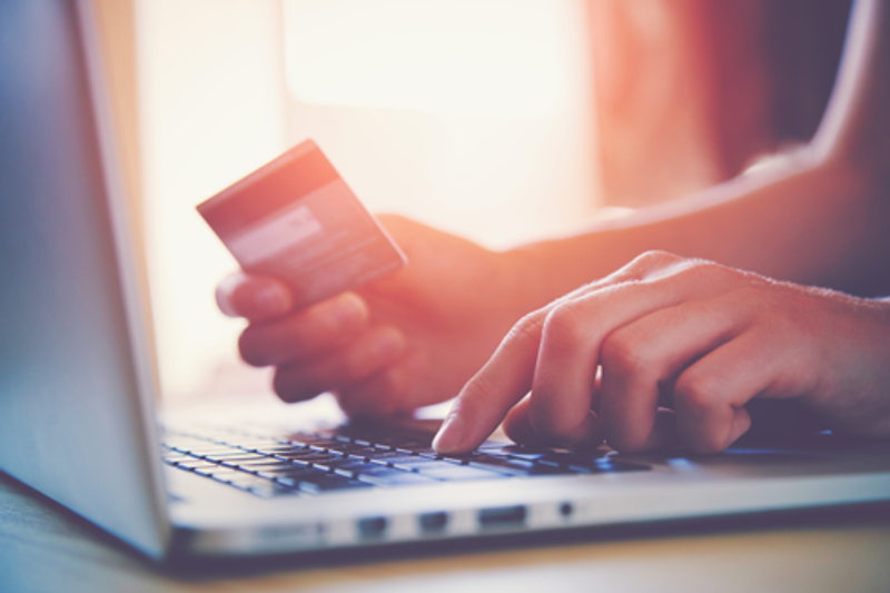 Woman inputting credit card details onto laptop