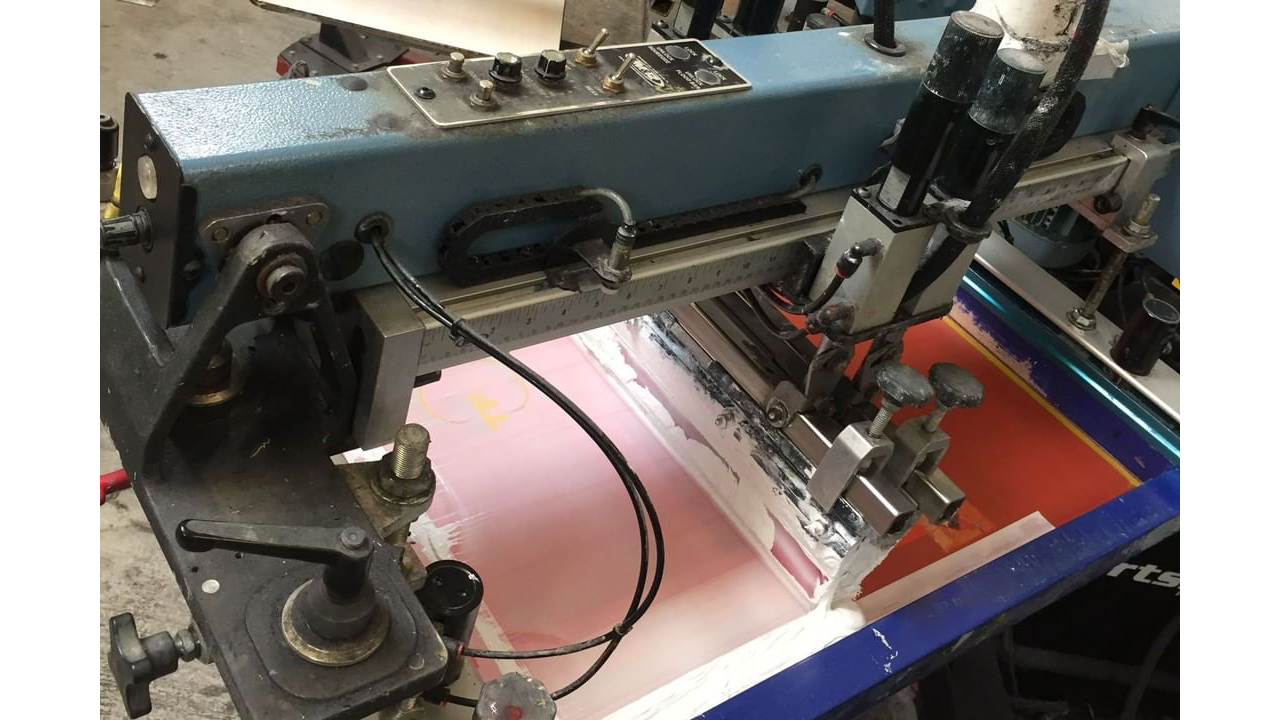 An automatic screen printing squeegee in the process of screen printing.