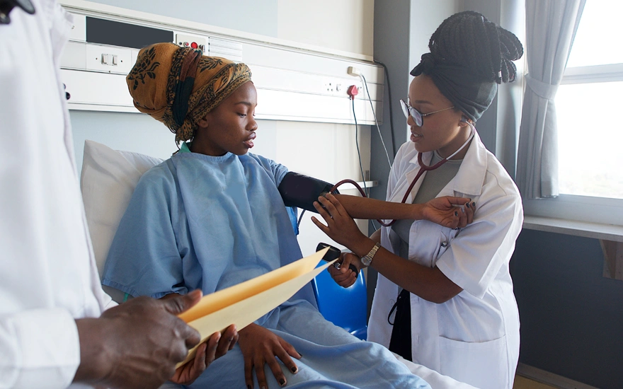 Female Doctor taking blood pressure on patient in a hospital