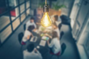 people in conference room with lightbulb in focus