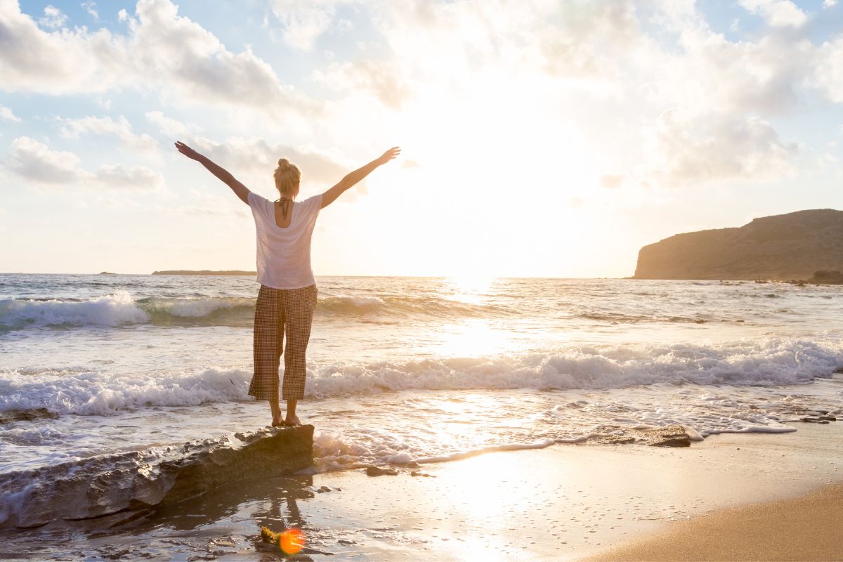 Woman on beach celebrating a "free" Medicare Advantage plan