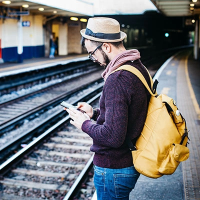 Man on his phone at train station.