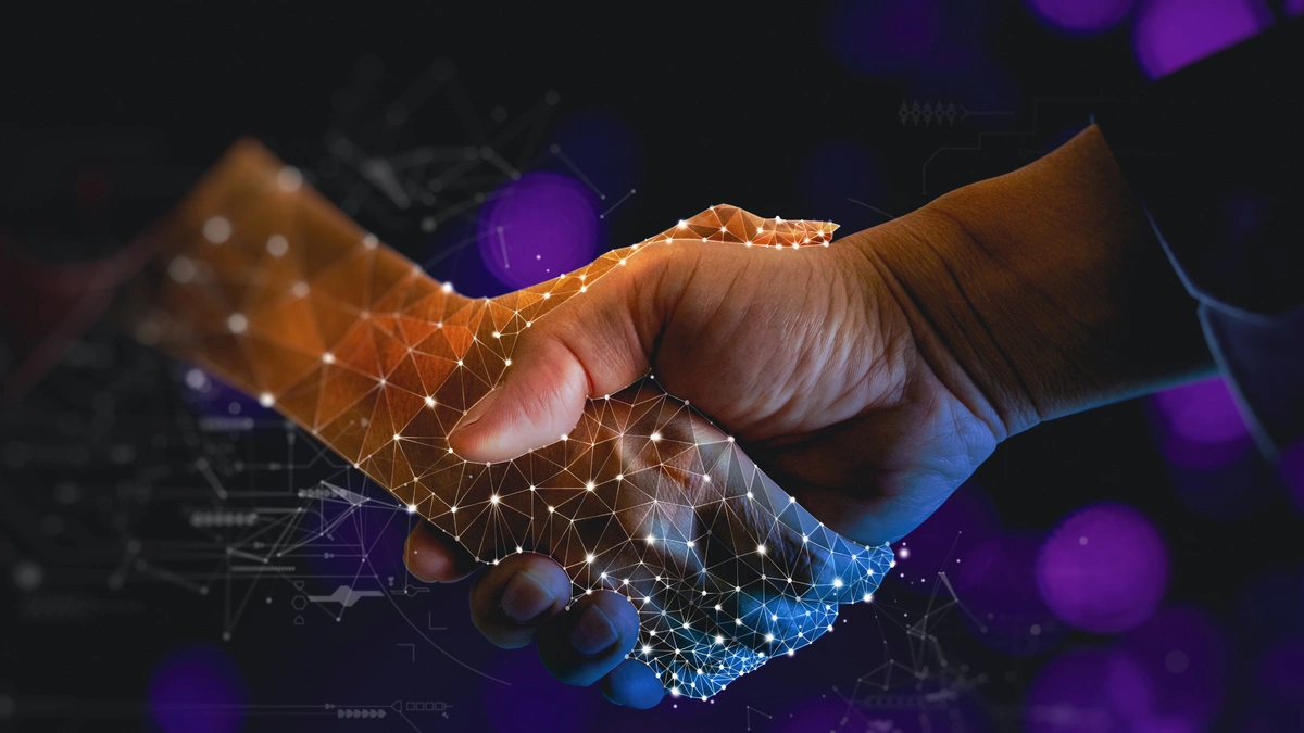 Digital transformation and innovation concept with two hands engaging in a handshake, overlaid with glowing network connections and abstract technological graphics on a dark background