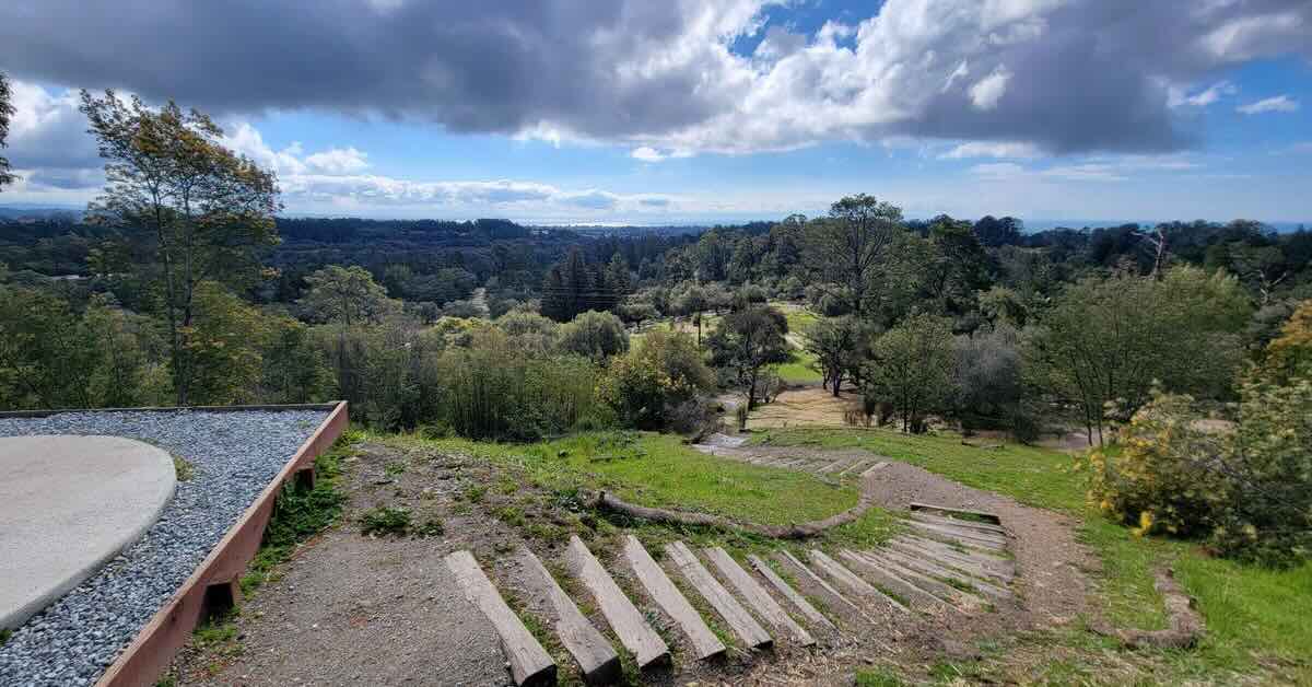 Stairs lead away from a disc golf tee pad with an epic view from an elevated position